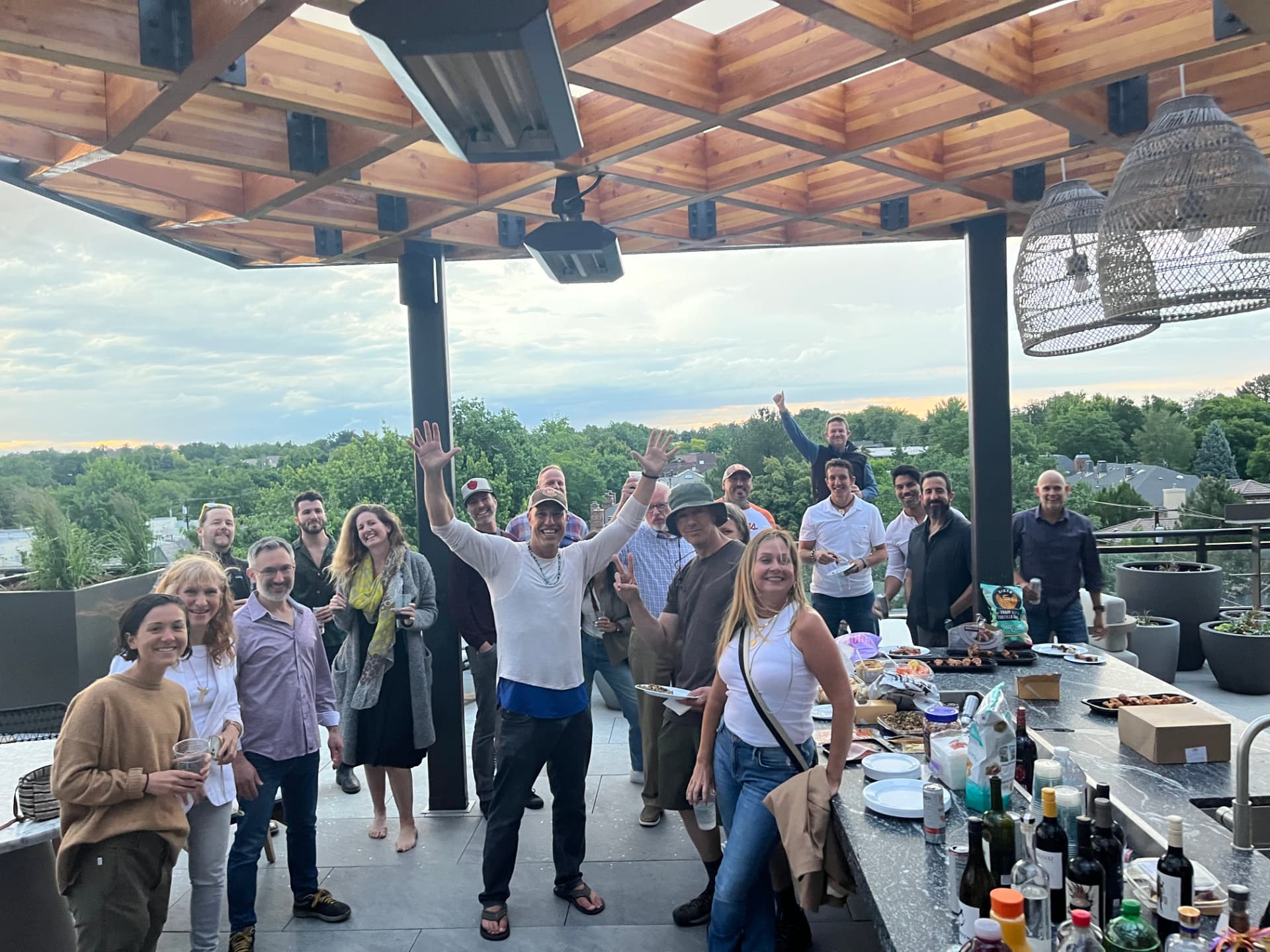 316 community gathered on a rooftop patio at sunset